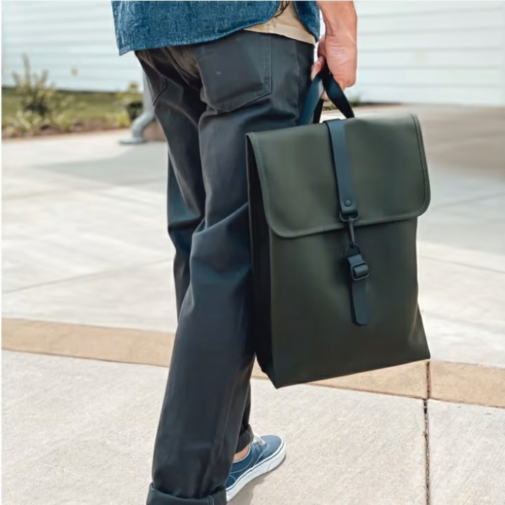 Backpack is cut in Rains’ signature waterproof PU fabric. Dark green large